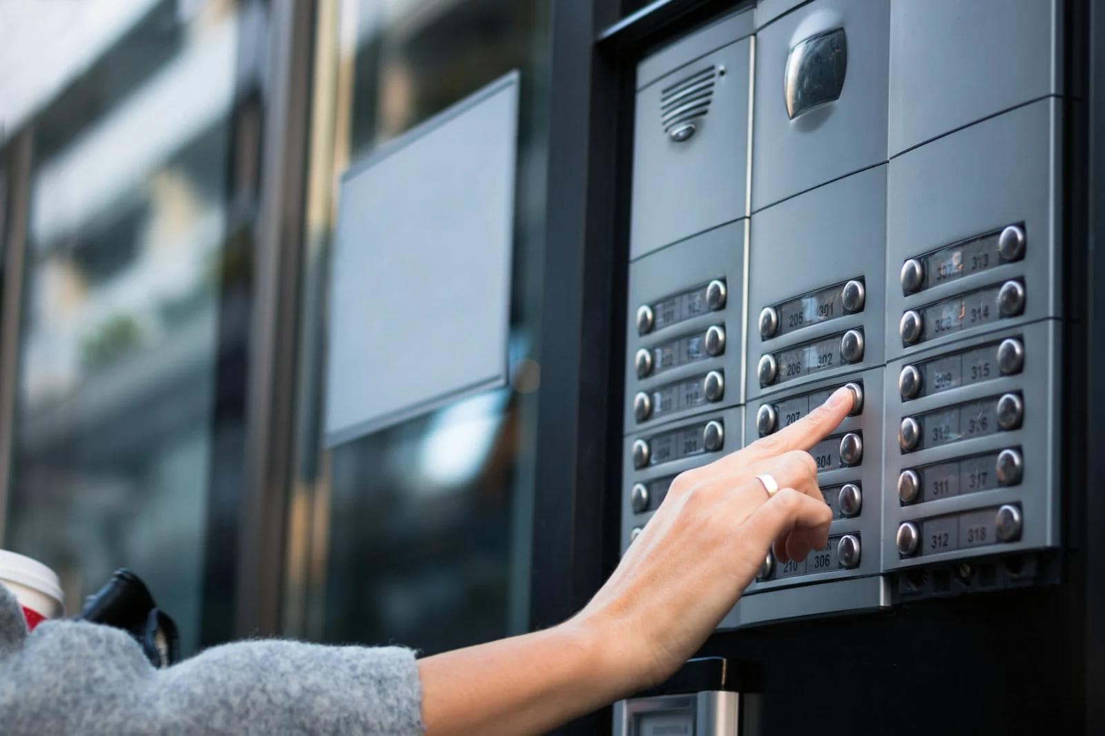 Woman pressing a button on an intercom system